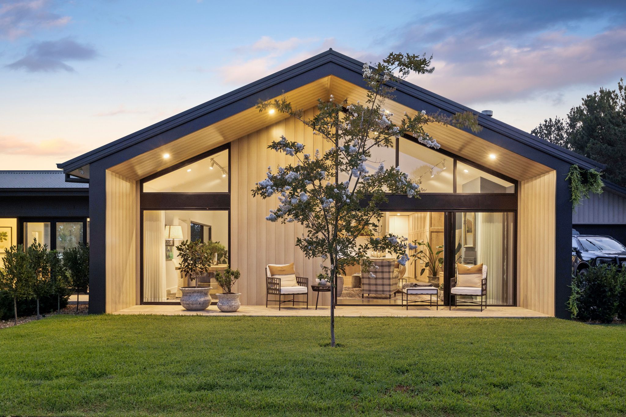 A Goulburn home glowing at dusk beneath its old gum tree